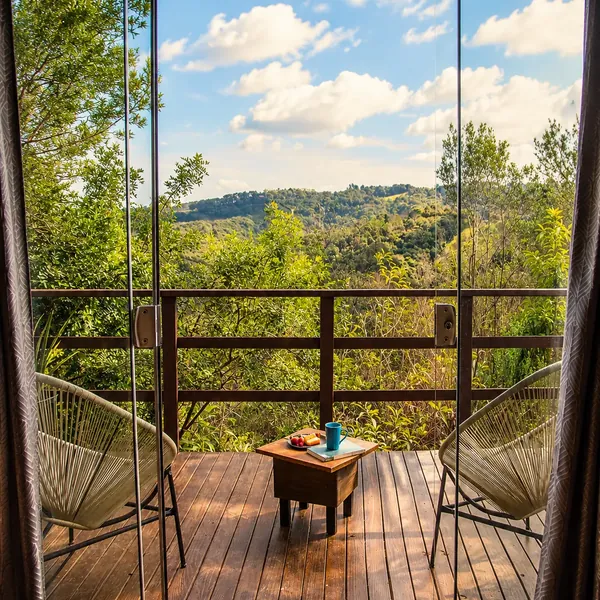 Coletivo Bambu a Pique - Cabana Lua, porta de vidro aberta para a varanda com vista para o vale