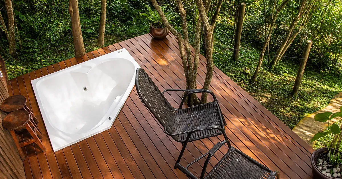 Coletivo Bambu a Pique - Cabana Vibe, banheira no deck de madeira cercado pelo bosque